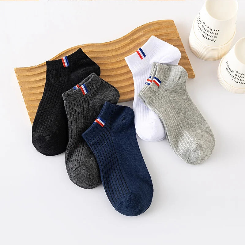 5 pares de calcetines finos de verano para hombre en diferentes colores sobre una superficie de madera.