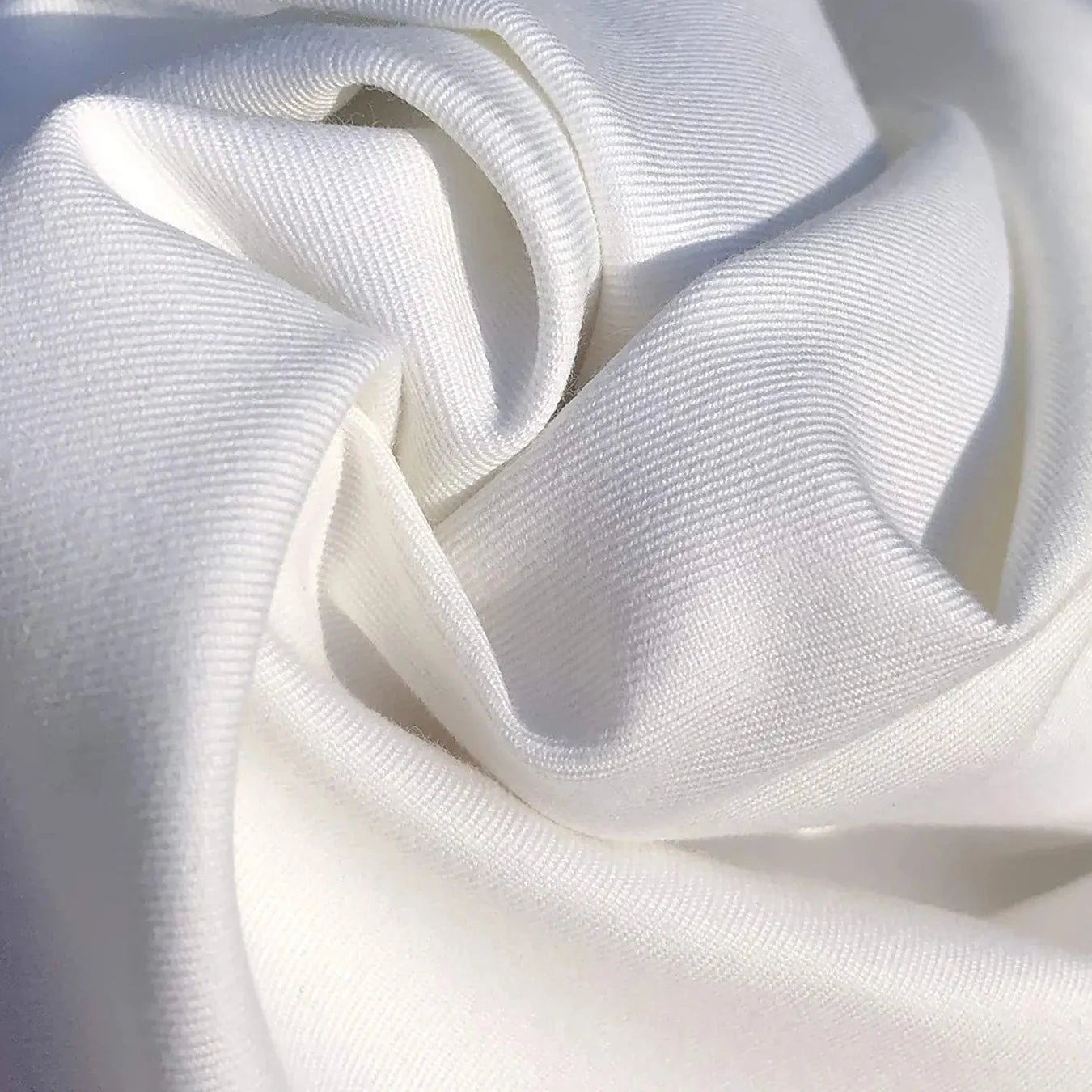 Primer plano de la textura de una tela de algodón blanca, ideal para camisetas divertidas de gato para mujer.